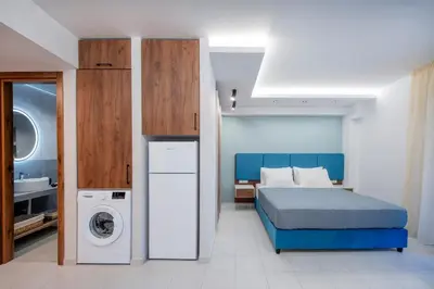 a bedroom with a bed and a washing machine at Dorothea Apartments #2 with garden view in Koskinou