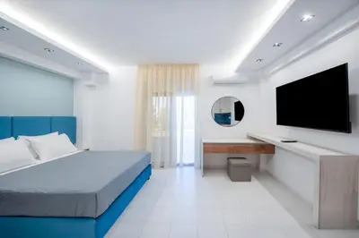 a bedroom with a bed and a flat screen tv at Dorothea Apartments #2 with garden view in Koskinou