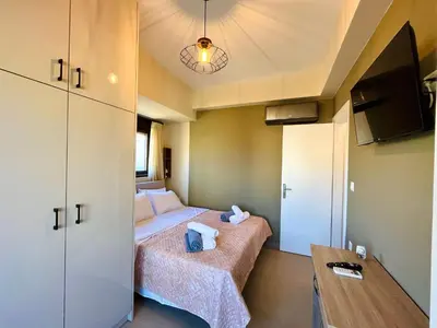 a small room with two beds and a table at Villa Greige in Ialyssos