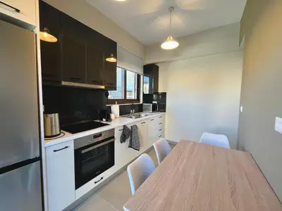 a kitchen with a table and chairs in a room at Villa Greige in Ialyssos