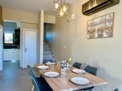 a dining room with a wooden table and chairs at Villa Greige in Ialyssos