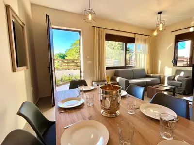 a dining room with a table and chairs at Villa Greige in Ialyssos