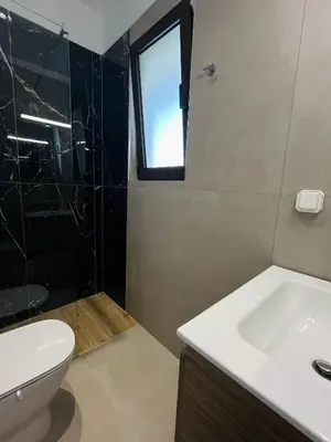 a bathroom with a sink and a toilet and a window at Villa Greige in Ialyssos