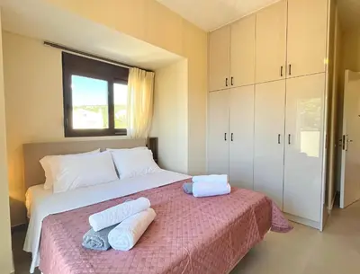a bedroom with a large bed with towels on it at Villa Greige in Ialyssos