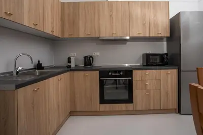 a kitchen with wooden cabinets and a sink and a microwave at La Maison Antique in Rhodes Town