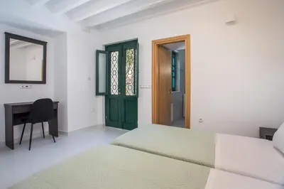 a bedroom with two beds and a desk at La Maison Antique in Rhodes Town