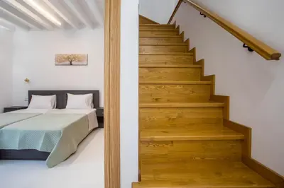 a bedroom with a bed and a staircase at La Maison Antique in Rhodes Town