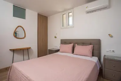 a bedroom with a large bed with pink pillows at La Maison Antique in Rhodes Town