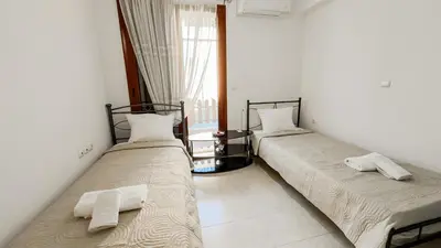 two beds in a room with white walls at Angela's Green Escape in Triánta