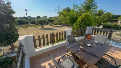 a wooden table and chairs on a patio at Angela's Green Escape in Triánta