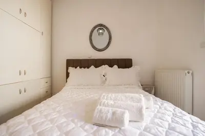 a bedroom with a white bed with two towels on it at Angela's Green Escape in Triánta