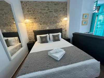a bedroom with a large bed with a mirror at My Symi Apartments in Symi