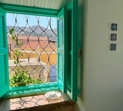 an open window with a view of a field at My Symi Apartments in Symi