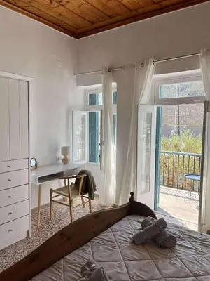 a bedroom with a bed and a desk and a window at Seaside House in Symi