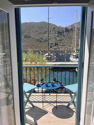 a balcony with a table and a view of the water at Seaside House in Symi
