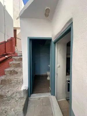 a hallway to a bathroom with a toilet in a building at Seaside House in Symi