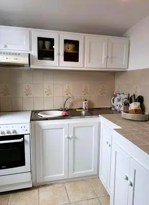 a kitchen with white cabinets and white appliances at Seaside House in Symi