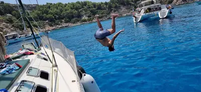 a person jumping off of a boat in the water at Sailing Edisa Rhodes Adventures in Rhodes Town
