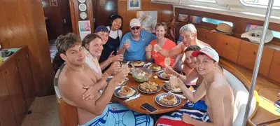 a group of people sitting around a table eating food at Sailing Edisa Rhodes Adventures in Rhodes Town