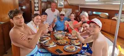 a group of people sitting around a table eating food at Sailing Edisa Rhodes Adventures in Rhodes Town