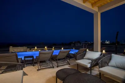 a patio with chairs and a table at night at Blue Sunrise Villa 1 in Afantou