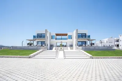 a large white building with stairs in front of it at Blue Sunrise Villa 1 in Afantou