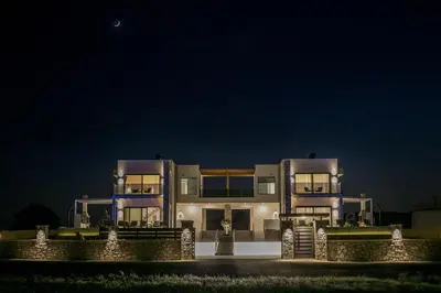 a large building with lights in front of it at night at Blue Sunrise Villa 1 in Afantou