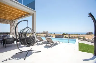 a swing on the patio of a house at Blue Sunrise Villa 1 in Afantou