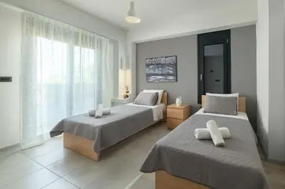 a bedroom with two beds and a window at Harmony Villas Rhodes in Ialyssos