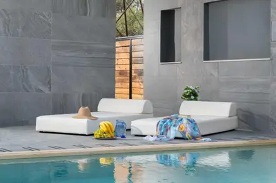 two beds sitting next to a swimming pool at Harmony Villas Rhodes in Ialyssos