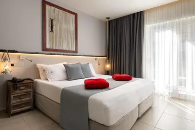 a bedroom with a large bed with red pillows on it at Elakati Luxury Boutique Hotel - Adults Only in Rhodes Town