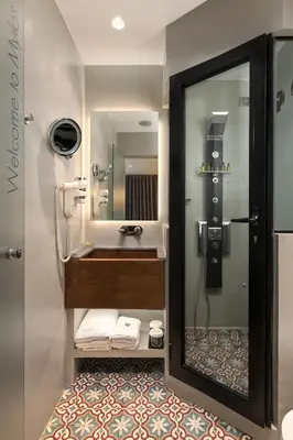 a bathroom with a shower with a sink and a mirror at Elakati Luxury Boutique Hotel - Adults Only in Rhodes Town