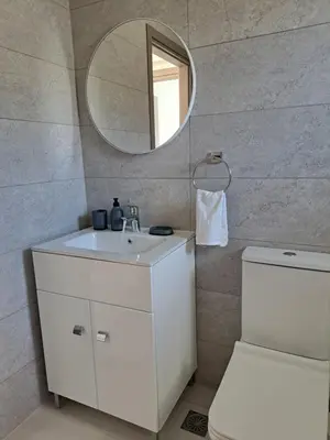 a bathroom with a white sink and a mirror at Giannis Apartment in Afantou