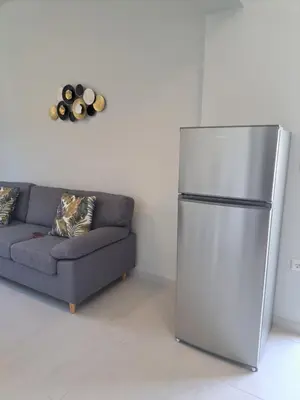 a living room with a refrigerator and a couch at Giannis Apartment in Afantou
