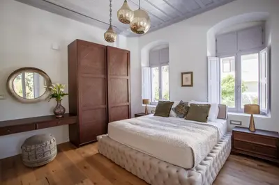 a bedroom with a large bed and a mirror at Aylin Executive Suites in Rhodes Town