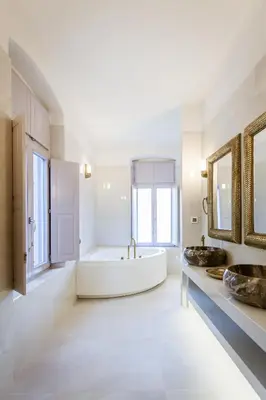a bathroom with two sinks and a large tub at Aylin Executive Suites in Rhodes Town