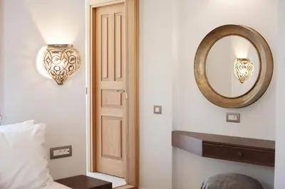 a bedroom with a door and a mirror on the wall at Aylin Executive Suites in Rhodes Town