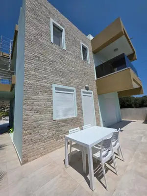 a white table and chairs in front of a building at Palm Marie - Rhodes in Kalithies