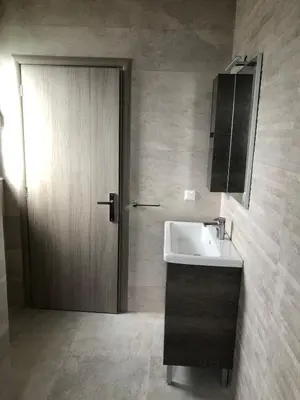 a bathroom with a sink and a wooden door at Palm Marie - Rhodes in Kalithies