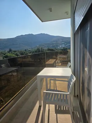 a white table and chair on a balcony with a view at Palm Marie - Rhodes in Kalithies