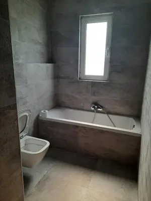 a bathroom with a tub and a toilet and a window at Palm Marie - Rhodes in Kalithies