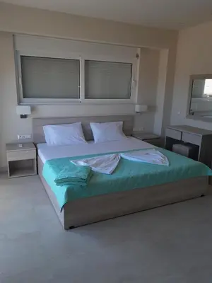 a bedroom with a large bed with two windows at Palm Marie - Rhodes in Kalithies