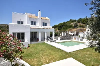 a white house with a yard with a swimming pool at Sofia Villa Near Faliraki in Kalithies