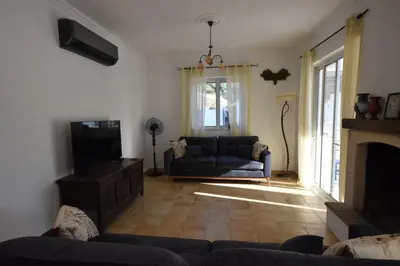 a living room with a couch and a television at Sofia Villa Near Faliraki in Kalithies