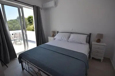 a bedroom with a bed and a sliding glass door at Sofia Villa Near Faliraki in Kalithies