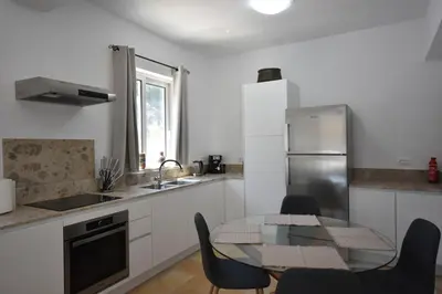 a kitchen with a table and chairs and a refrigerator at Sofia Villa Near Faliraki in Kalithies