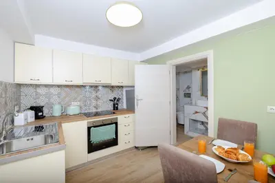 a kitchen with white cabinets and a table with food on it at Kolonaki Corner in Rhodes Town
