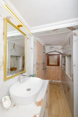 a white bathroom with a sink and a mirror at Kolonaki Corner in Rhodes Town