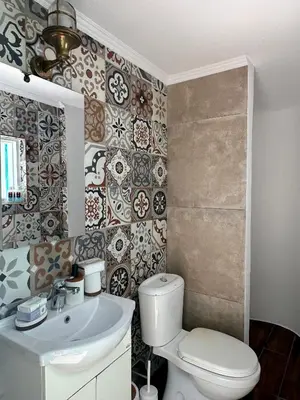 a bathroom with a toilet and a sink at Lindiakos Villa AMI in Symi