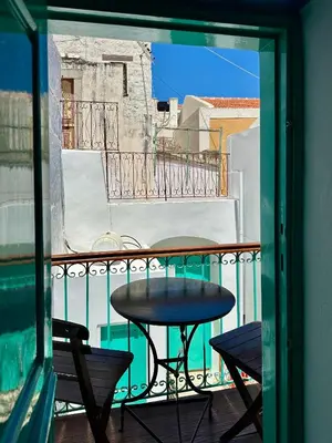 a balcony with a table and chairs on a balcony at Lindiakos Villa AMI in Symi